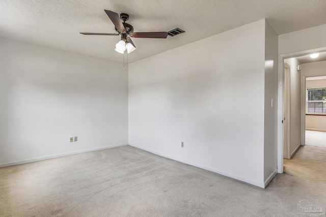 carpeted spare room featuring ceiling fan and a textured ceiling