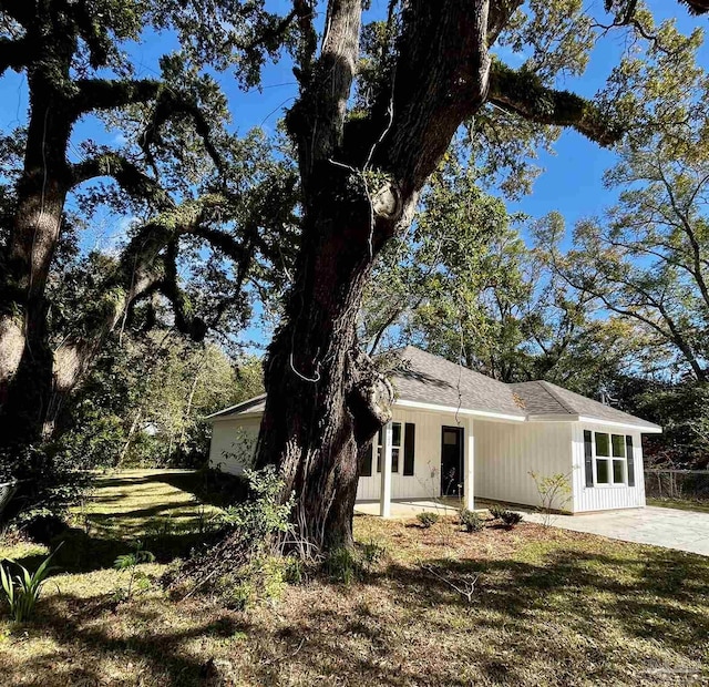 view of front of property with a patio area, a front yard, and fence