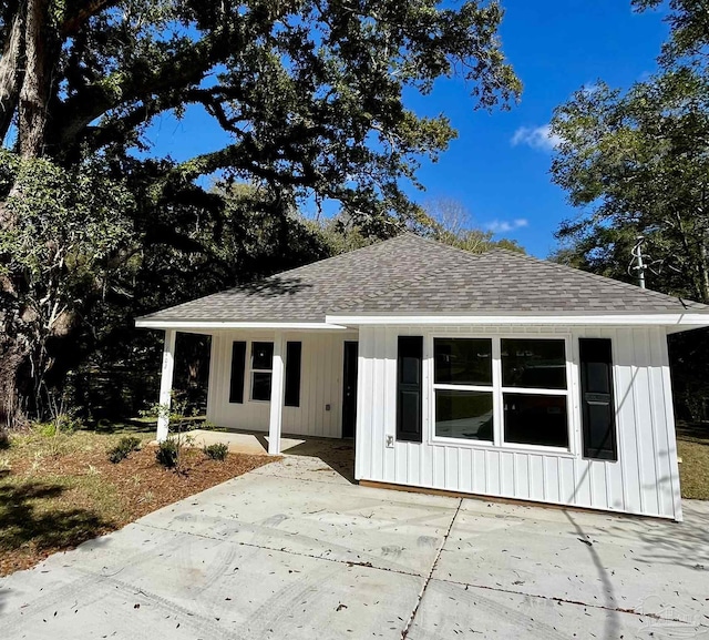 view of front of property featuring a patio area, board and batten siding, and roof with shingles