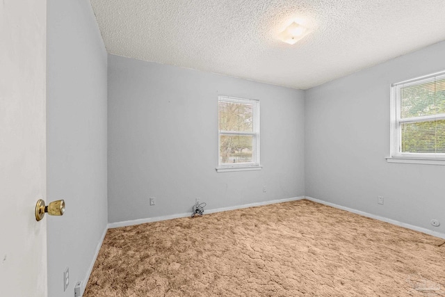 carpeted empty room featuring a textured ceiling