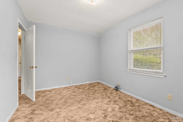 carpeted empty room featuring a textured ceiling