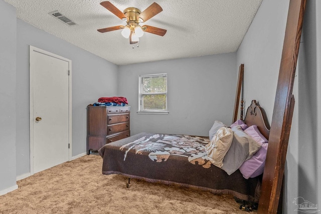 bedroom with ceiling fan, carpet flooring, and a textured ceiling