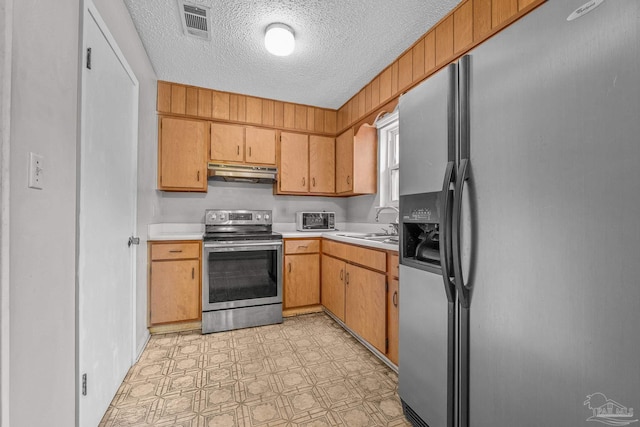 kitchen featuring sink, a textured ceiling, and appliances with stainless steel finishes