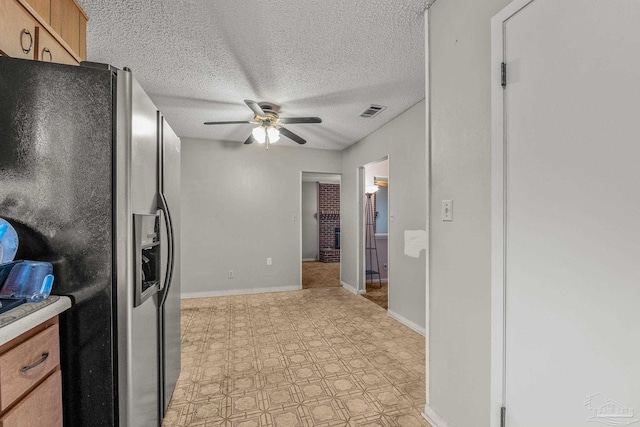 kitchen featuring a textured ceiling, stainless steel fridge, and ceiling fan