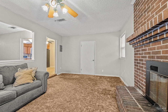 living room with a textured ceiling, a fireplace, ceiling fan, and dark colored carpet