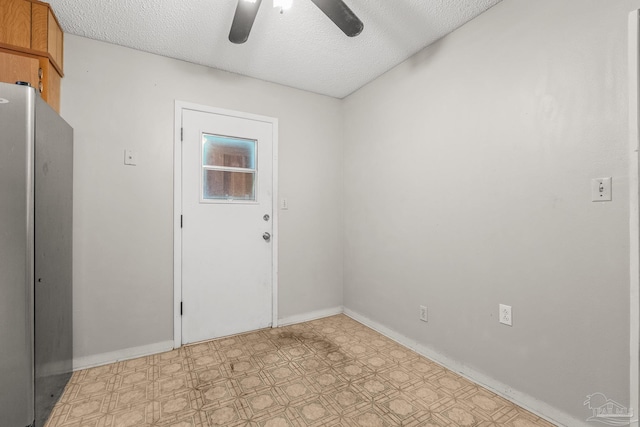 empty room featuring ceiling fan and a textured ceiling