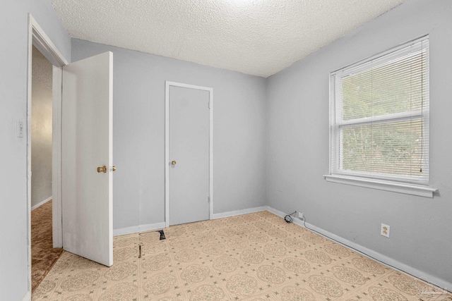 unfurnished bedroom with a textured ceiling and a closet