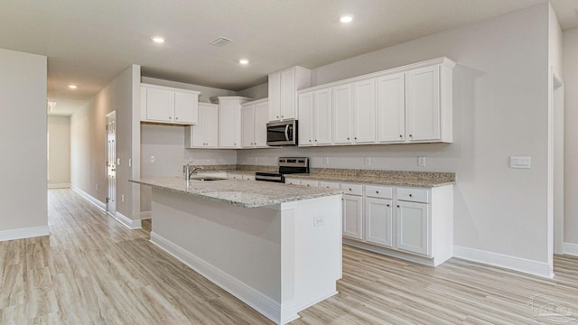 8616 Bluebell St, Milton, FL 32583 - kitchen featuring appliances with stainless steel finishes, light wood finished floors, baseboards, white cabinets, and recessed lighting