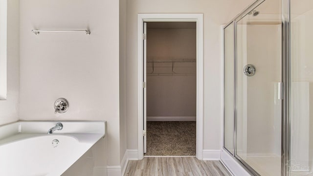 8616 Bluebell St, Milton, FL 32583 - bathroom with a stall shower, a spacious closet, wood finished floors, and a garden tub