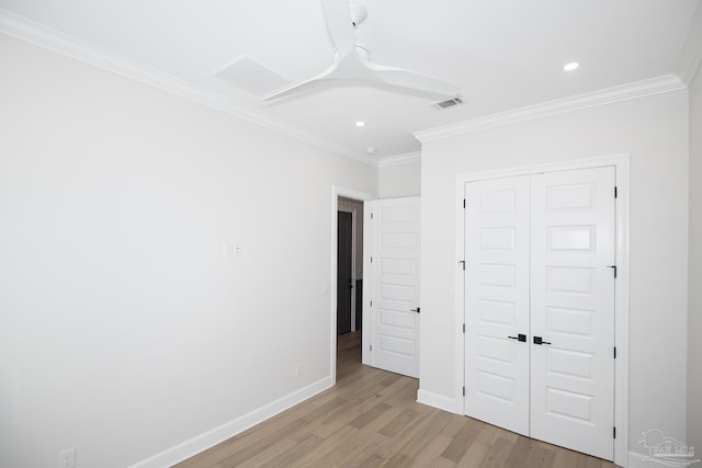 unfurnished bedroom with baseboards, visible vents, light wood-style flooring, ornamental molding, and a closet