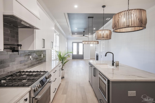 kitchen with crown molding, french doors, custom exhaust hood, stainless steel appliances, and a sink