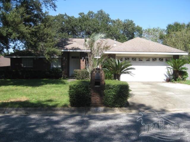 ranch-style house featuring a garage and a front lawn