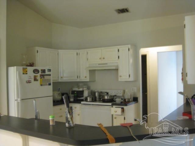 kitchen with white cabinets, kitchen peninsula, and white appliances