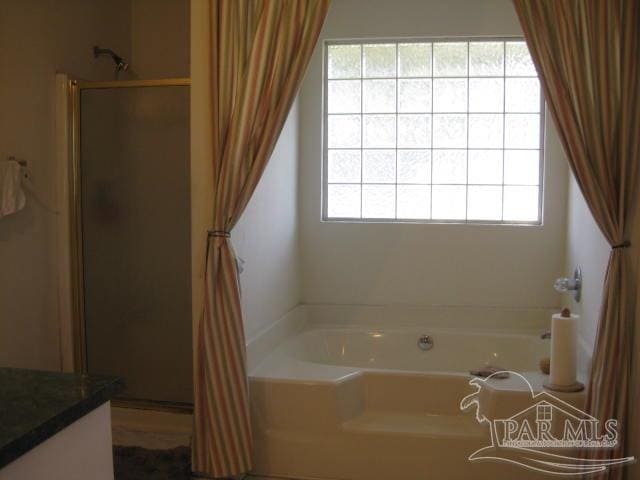 bathroom with shower with separate bathtub and a healthy amount of sunlight