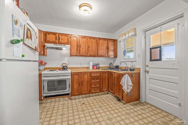 kitchen with white fridge, sink, and electric range