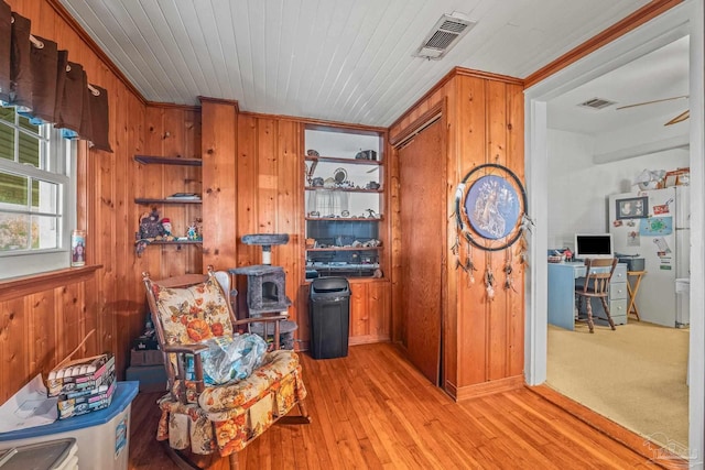 living area featuring light hardwood / wood-style floors and wood walls