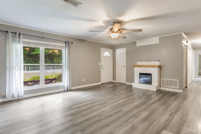 6845 Trail Ride S, Milton, FL 32570 - unfurnished living room featuring a ceiling fan, a fireplace, wood finished floors, crown molding, and baseboards