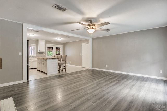 6845 Trail Ride S, Milton, FL 32570 - unfurnished living room featuring ceiling fan, crown molding, light wood-style flooring, and baseboards