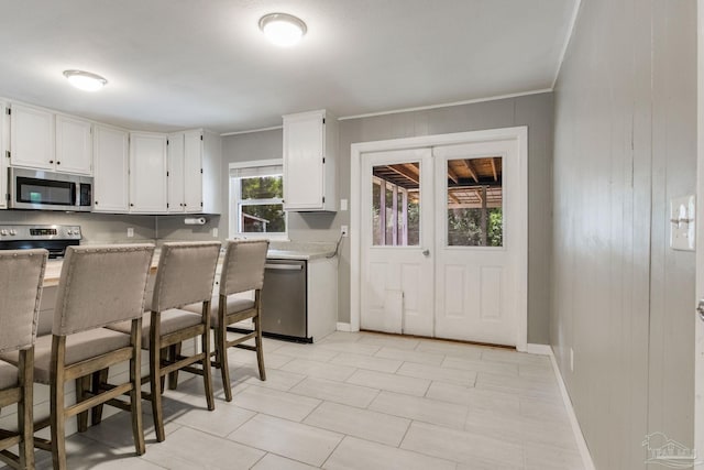 6845 Trail Ride S, Milton, FL 32570 - kitchen with appliances with stainless steel finishes, white cabinetry, ornamental molding, light countertops, and baseboards