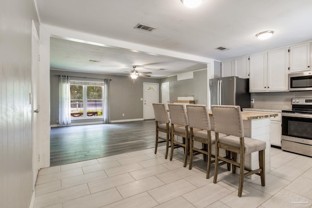 6845 Trail Ride S, Milton, FL 32570 - kitchen featuring stainless steel appliances, white cabinets, a ceiling fan, and light countertops