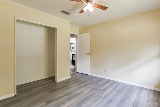 6845 Trail Ride S, Milton, FL 32570 - unfurnished bedroom featuring wood finished floors, crown molding, a ceiling fan, a closet, and baseboards