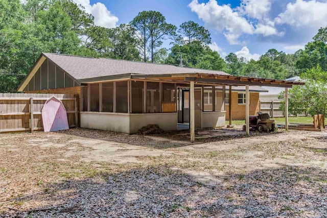 6845 Trail Ride S, Milton, FL 32570 - back of house featuring a sunroom, fence, roof with shingles, and board and batten siding