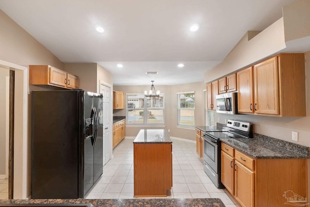 kitchen with a center island, dark stone counters, stainless steel appliances, and an inviting chandelier