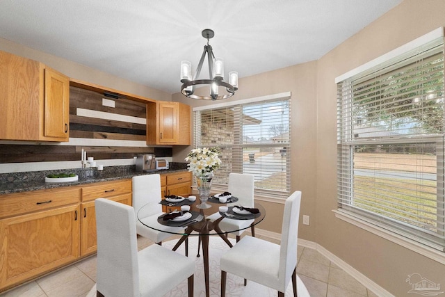 dining room with light tile patterned floors, baseboards, and a chandelier