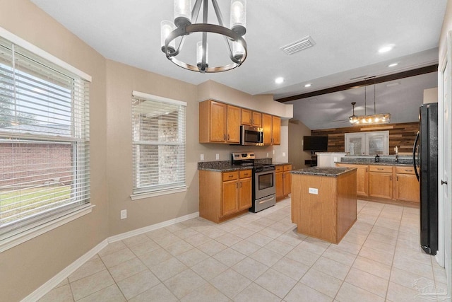 kitchen with visible vents, a kitchen island, lofted ceiling with beams, plenty of natural light, and appliances with stainless steel finishes