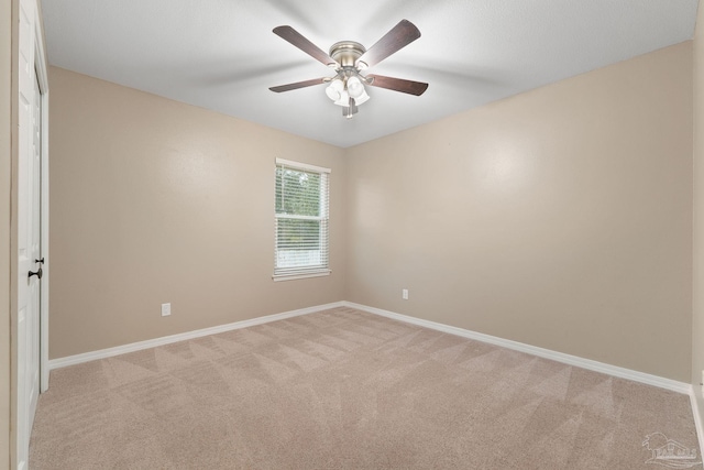 spare room with ceiling fan, baseboards, and light carpet