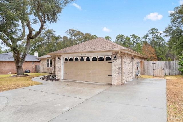 ranch-style house with a gate, driveway, an attached garage, a shingled roof, and brick siding