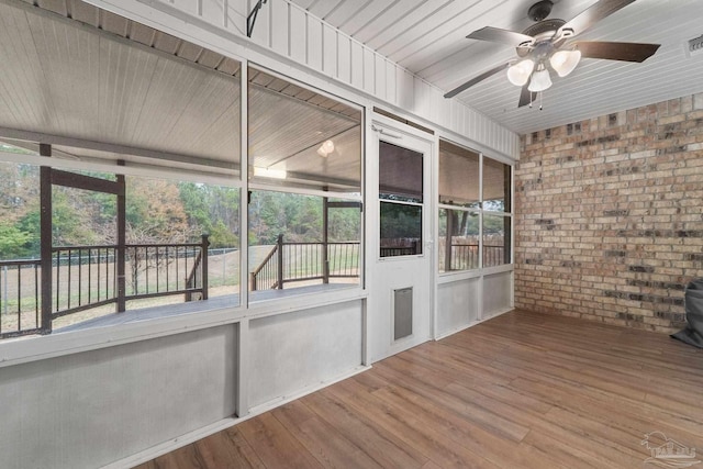 unfurnished sunroom with a ceiling fan and visible vents