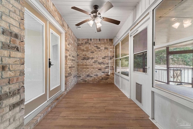 unfurnished sunroom with ceiling fan