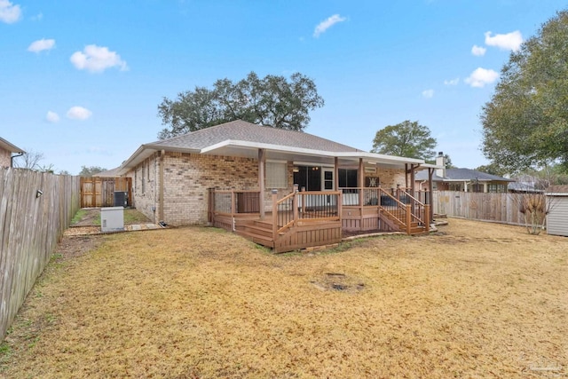 back of property with a yard, a fenced backyard, brick siding, and roof with shingles