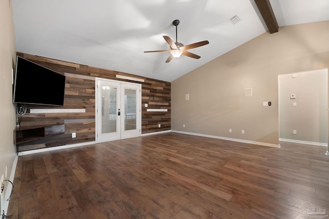 unfurnished living room featuring visible vents, lofted ceiling with beams, hardwood / wood-style floors, french doors, and wooden walls