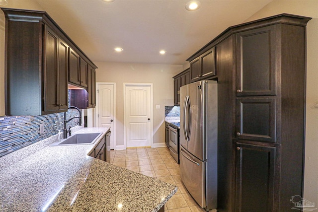 kitchen featuring stainless steel appliances, decorative backsplash, sink, light tile patterned floors, and dark brown cabinets