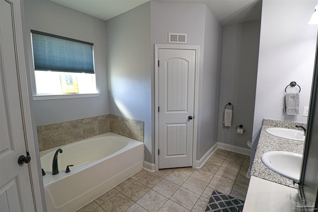 bathroom featuring toilet, vanity, tile patterned floors, and a washtub