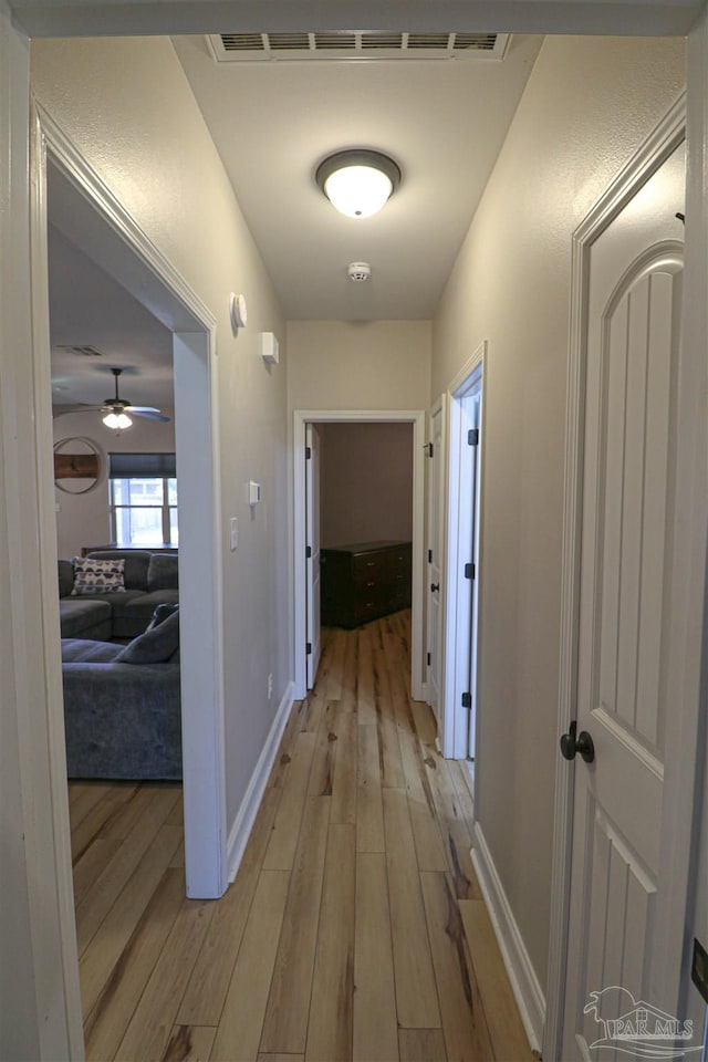 corridor with light hardwood / wood-style flooring