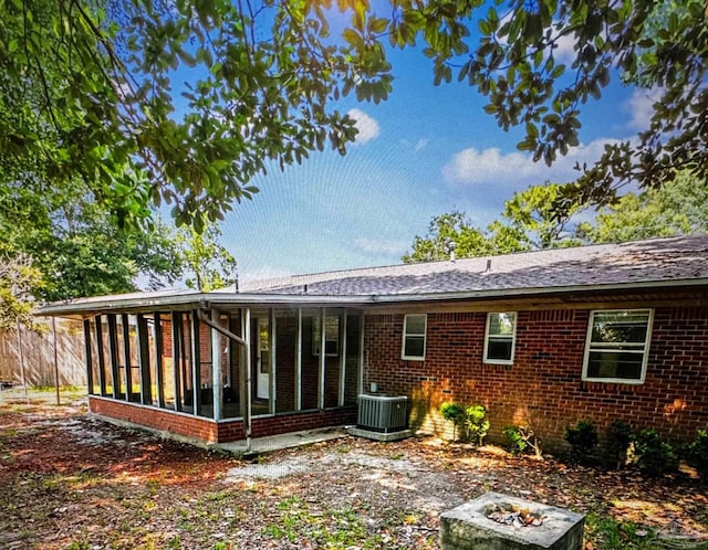 rear view of property with a sunroom and central AC unit