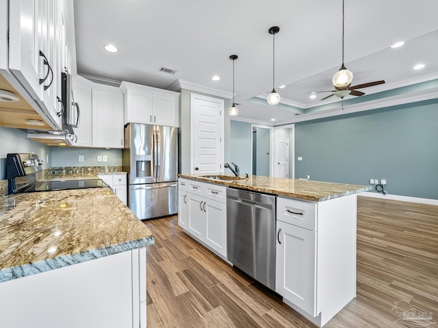 kitchen featuring white cabinets, appliances with stainless steel finishes, an island with sink, and ceiling fan