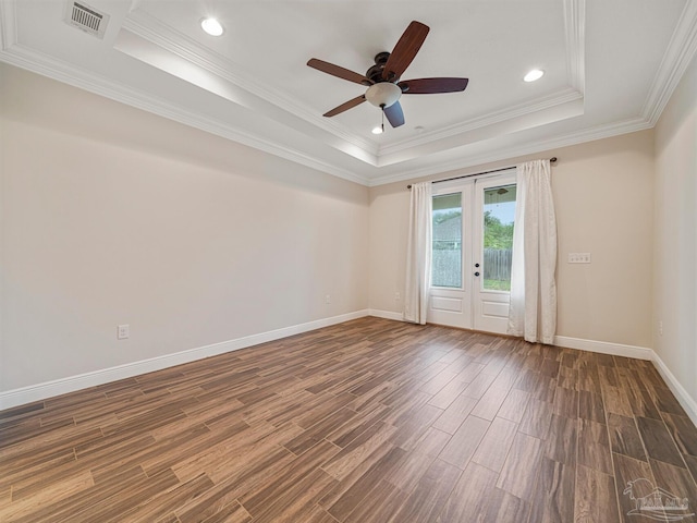 unfurnished room with ceiling fan, a raised ceiling, dark hardwood / wood-style flooring, and crown molding