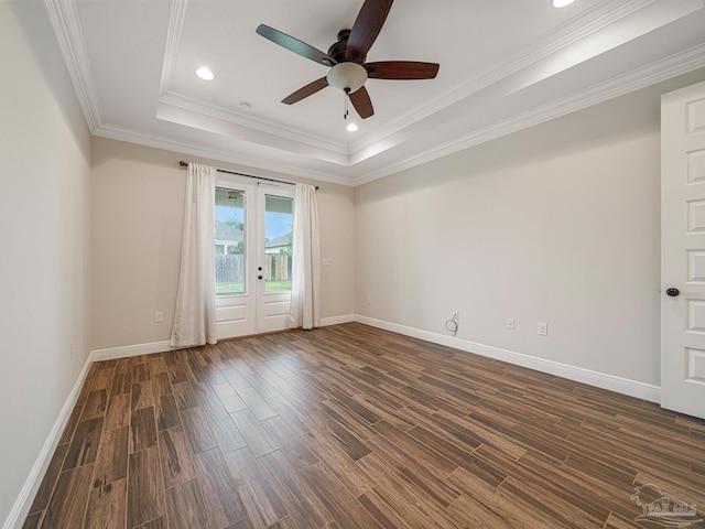 empty room featuring a raised ceiling, crown molding, french doors, ceiling fan, and dark wood-type flooring