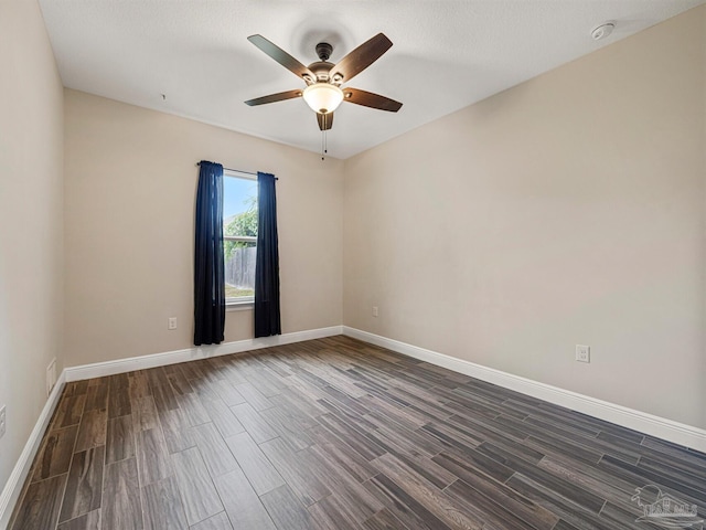 spare room with a textured ceiling, ceiling fan, and dark hardwood / wood-style floors