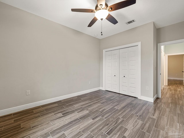 unfurnished bedroom with ceiling fan, dark hardwood / wood-style floors, and a closet