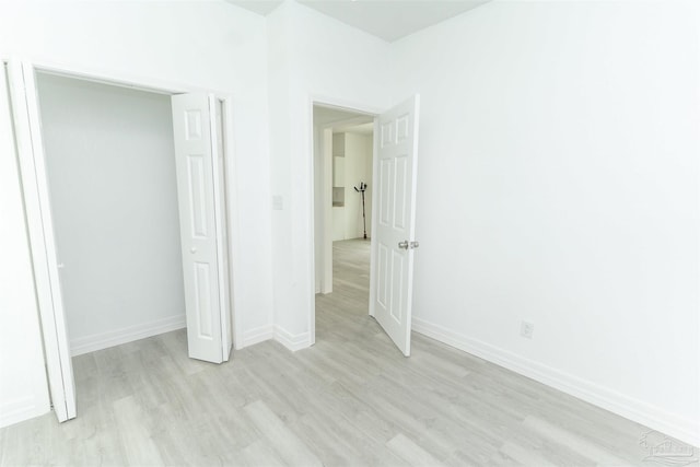 unfurnished bedroom featuring light wood-type flooring and a closet