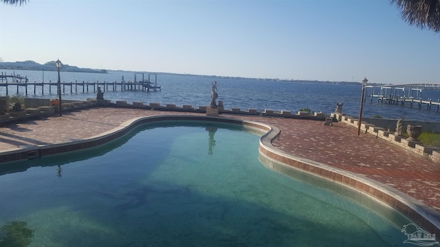 view of pool with a water view and a boat dock