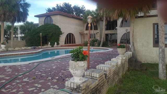 view of pool featuring a jacuzzi and a patio