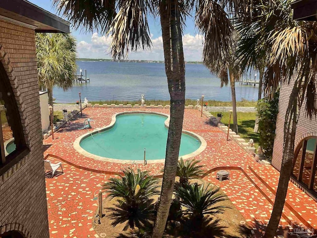 view of pool featuring a water view and a patio