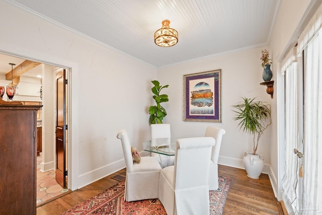 dining area with crown molding and hardwood / wood-style floors