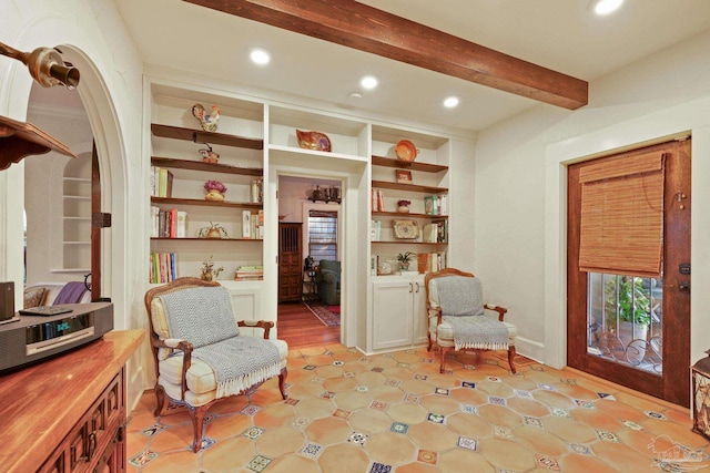 sitting room with built in features and beamed ceiling